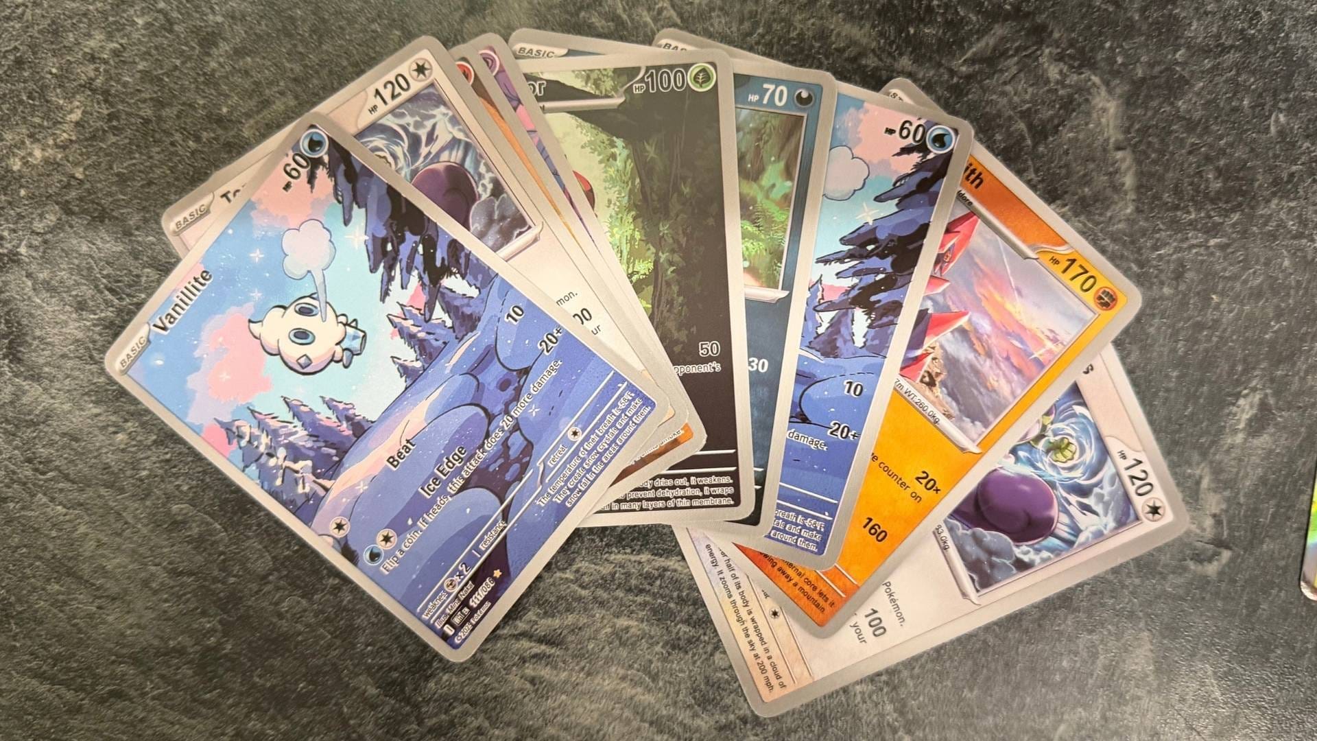 A selection of fake Pokémon cards fanned out on a marble countertop